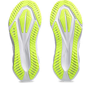 Pair of neon green running shoes with white soles on a white background