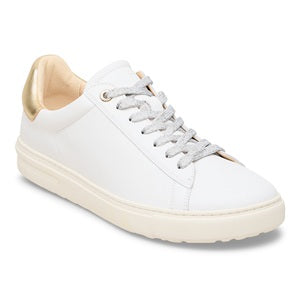 White sneaker with gold accents on a white background