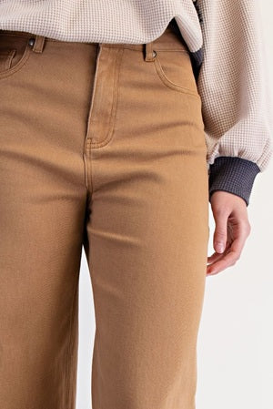 Brown pants worn by a person on a white background