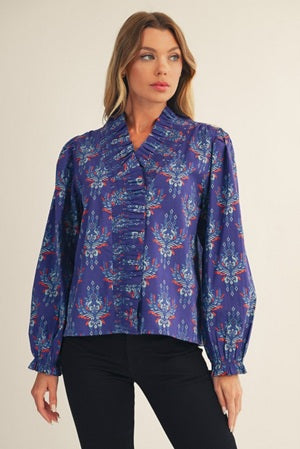 Woman wearing a blue patterned blouse against a plain background