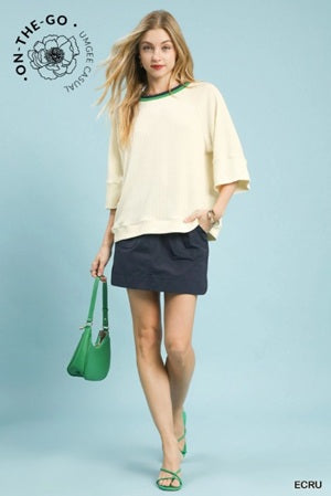 Women's cream-colored oversized short-sleeve top with a green collar trim