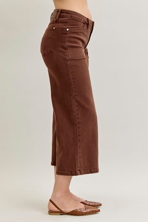 Brown wide-leg jeans worn by a person on a plain background