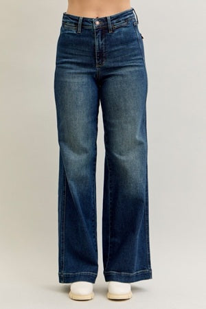 Blue jeans worn by a person on a plain background