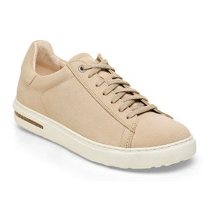 Tan sneaker with gold accents on a white background