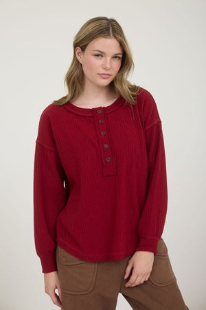 Deep red long sleeve shirt with buttons on an exposed edge placket with long sleeve shirt.