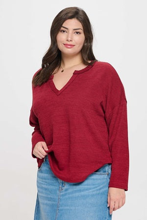 Woman wearing a red sweater and blue jeans on a white background