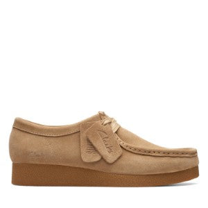 Tan suede shoe with a bow on a white background