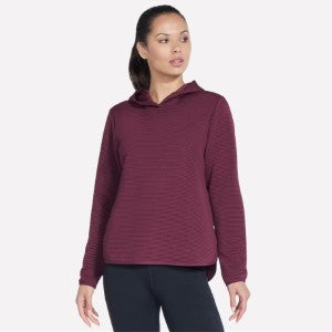Woman wearing a maroon hoodie on a white background