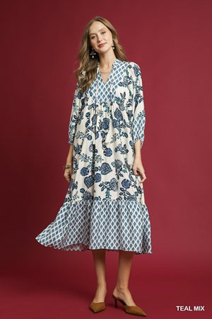 Woman wearing a floral dress with a teal and white pattern on a red background