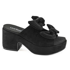 Black suede platform shoe with bow detail on a white background
