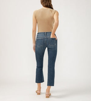 Person wearing blue jeans and a beige top on a white background