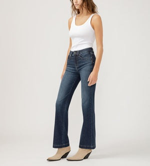 Woman wearing a white tank top and blue jeans on a white background