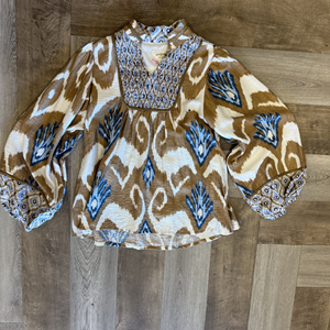 Traditional patterned blouse on a wooden surface