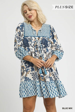 Woman wearing a blue and white patterned dress on a plain background
