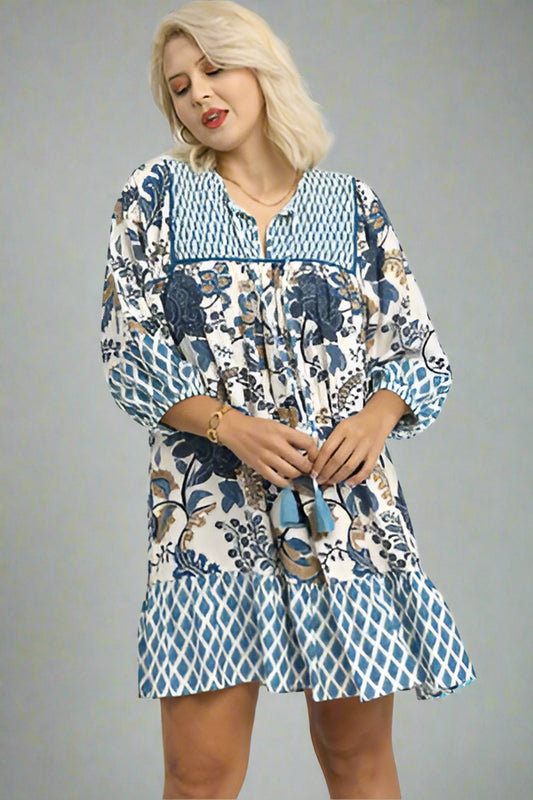 Woman wearing a patterned dress with a plain background