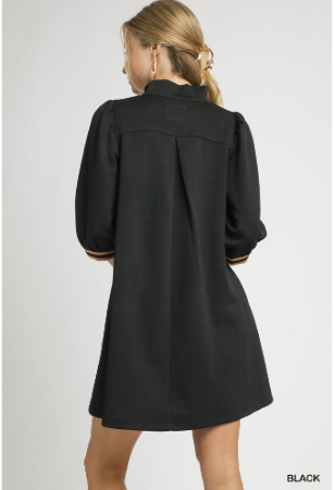 Black dress worn by a model on a light gray background