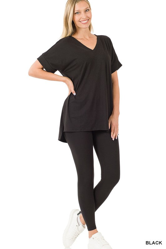 Woman wearing a black top and leggings on a white background