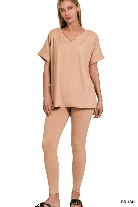Woman wearing a beige top and leggings on a white background